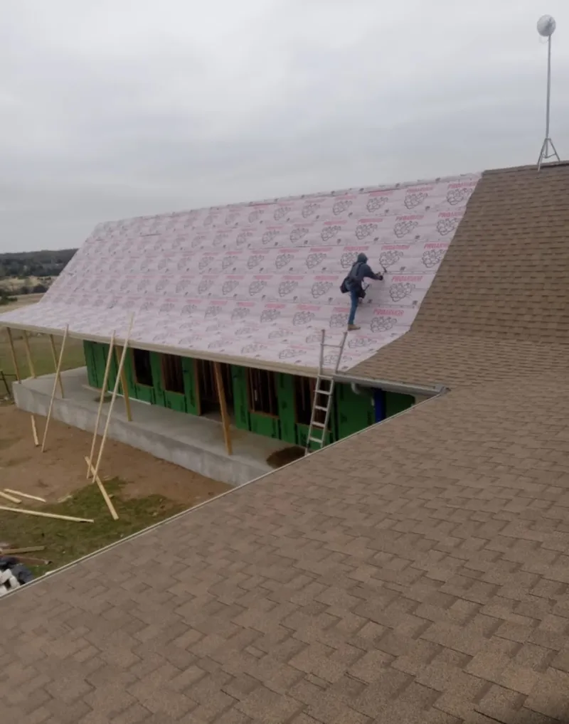 Worker preparing underlayment for a metal roof installation in Vacaville